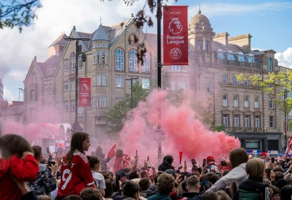 a crowd of people standing around a red smoke bomb