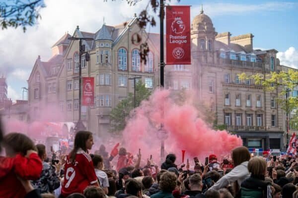 a crowd of people standing around a red smoke bomb